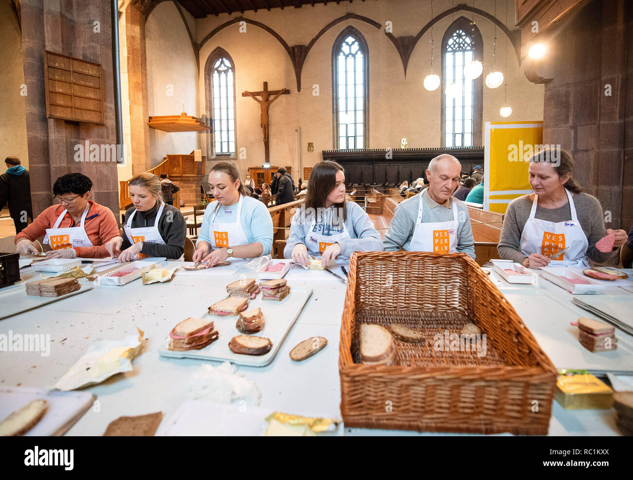 Stuttgart, Allemagne. 13 Jan, 2019. Les Bénévoles Faire du pain au cours de la première journée de l'église aux vêpres. Pour la 25e fois, la plus ancienne église Vesper en Allemagne fournit à des personnes dans le besoin avec des repas chauds et plus de sept semaines. Crédit : Sébastien Gollnow/dpa/Alamy Live News Banque D'Images