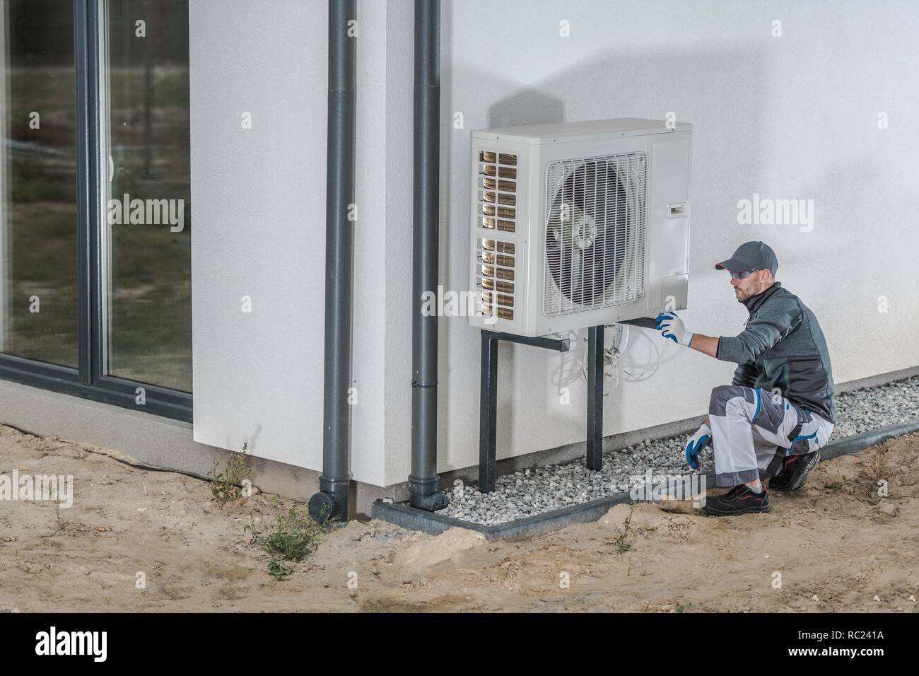 Projet d'installation de pompe à chaleur. Technicien en chauffage et refroidissement du Caucase l'installation de nouveau périphérique. Banque D'Images