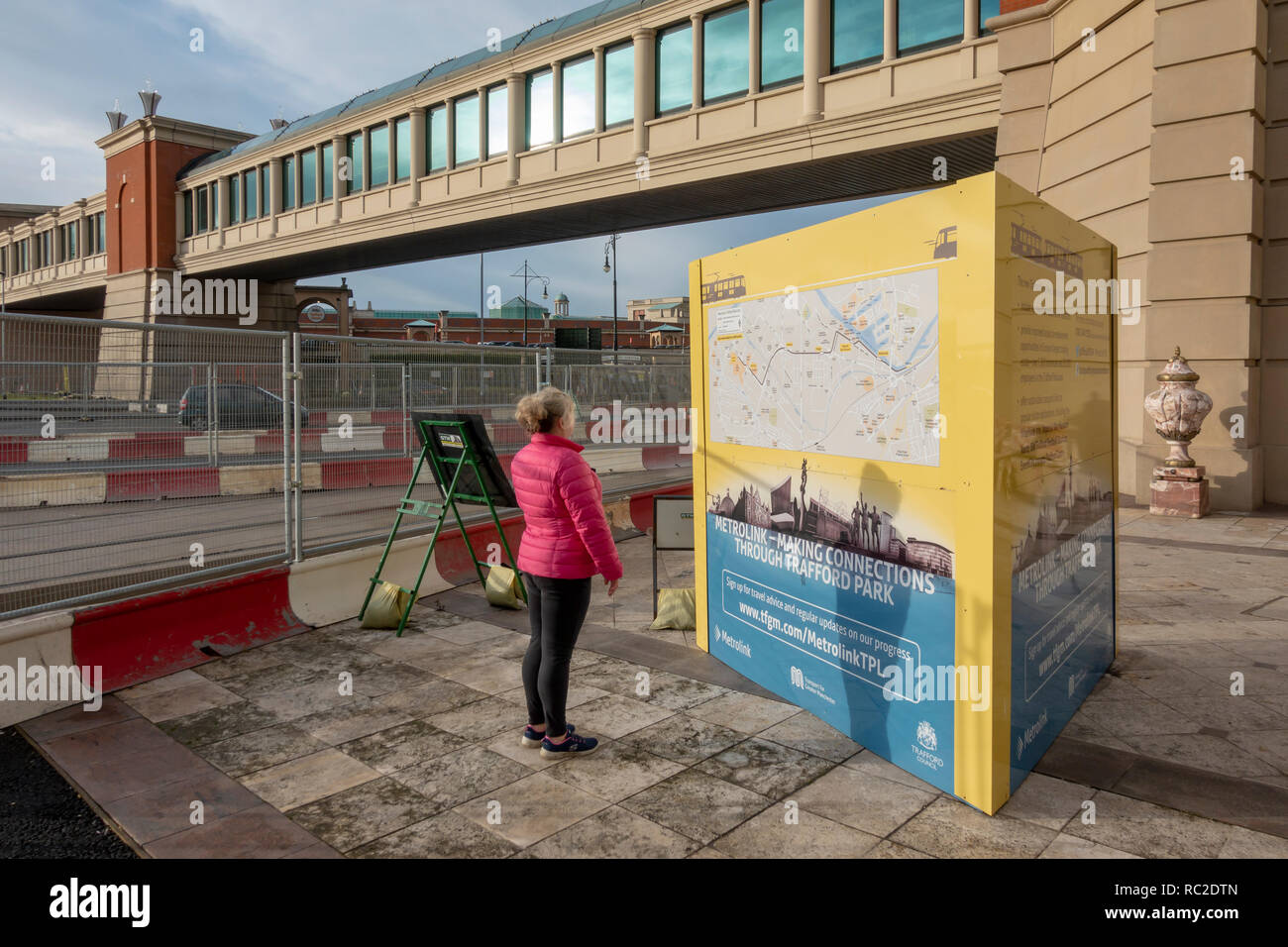 Femme à la recherche de plans pour la construction de lignes de métro de Trafford Park près de l'Intu Trafford Centre Banque D'Images