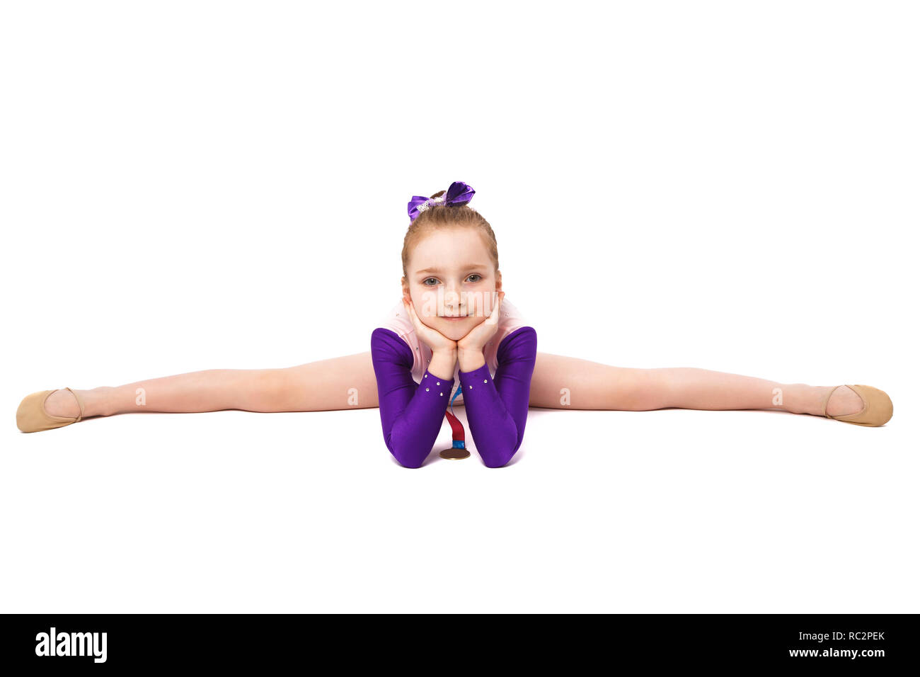 Petite fille gymnaste avec une médaille dans un maillot de sport faisant des exercices Banque D'Images