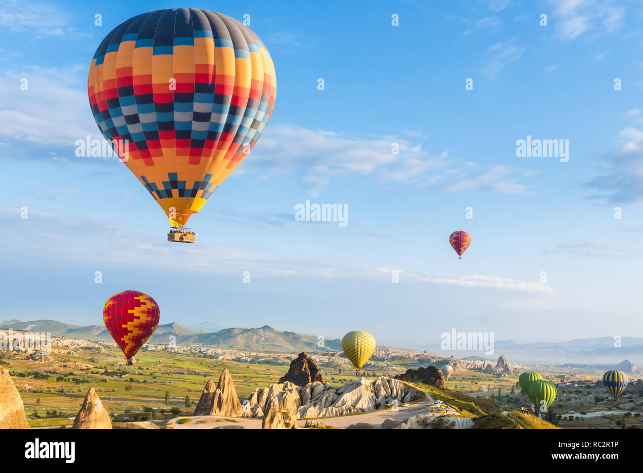 Hot Air Balloon flying over red poppies field région de Cappadoce, Turquie Banque D'Images