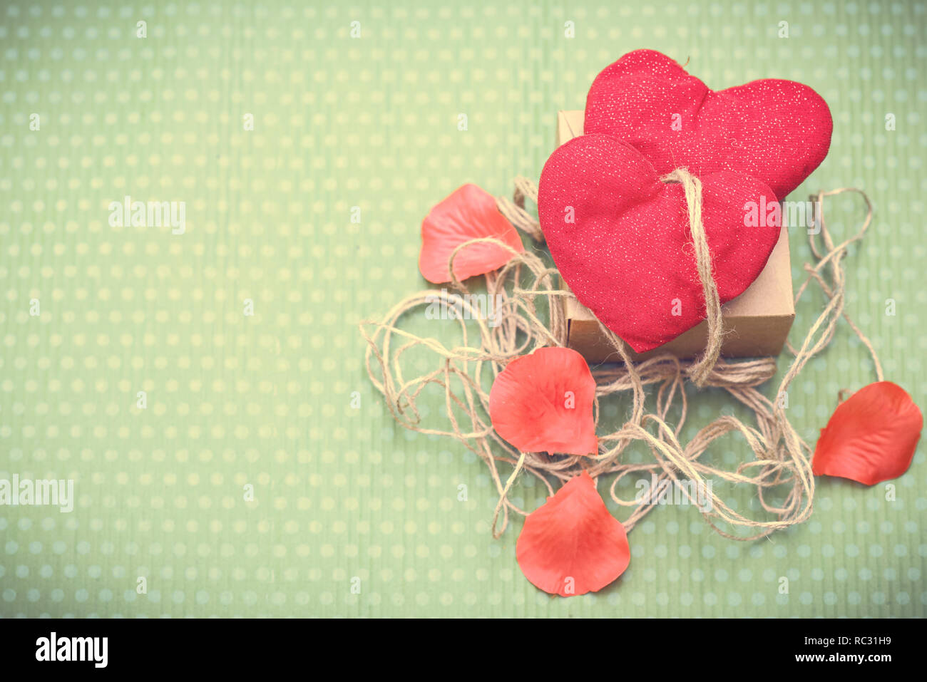 Valentines Day. Coeur rouge vintage mêlé de threads se trouve sur un beau fond vert. Le jour de la Saint-Valentin. Pendentif Coeur. L'espace pour le texte. Entendre rouge Banque D'Images