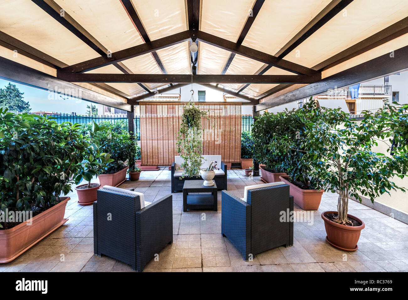 Terrasse couverte avec mobilier d'extérieur et plantes. - Image Banque D'Images