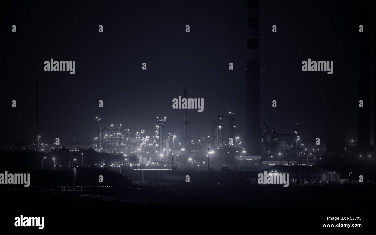 Panorama d'une partie d'une grande raffinerie par nuit. Converti en noir et blanc. Tons bleu. Banque D'Images