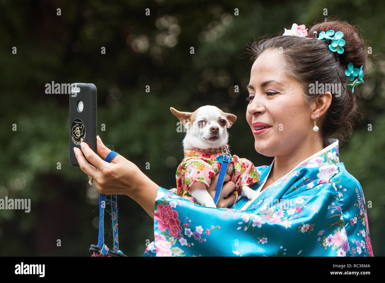 Une femme portant un kimono prend une comme elle tient son selfies petit chien, vêtu d'un kimono costume, à Doggy Con à Atlanta, GA, le 18 août 2018. Banque D'Images