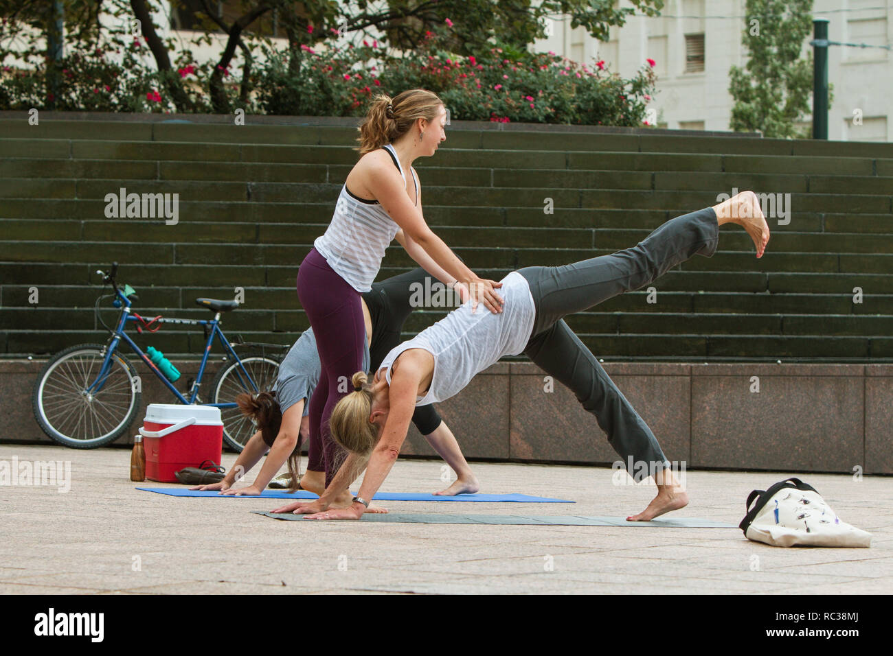 Une jeune femme professeur de yoga enseigne le yoga positions pour les femmes dans une classe à Woodruff Park le 18 août 2018 à Atlanta, GA. Banque D'Images