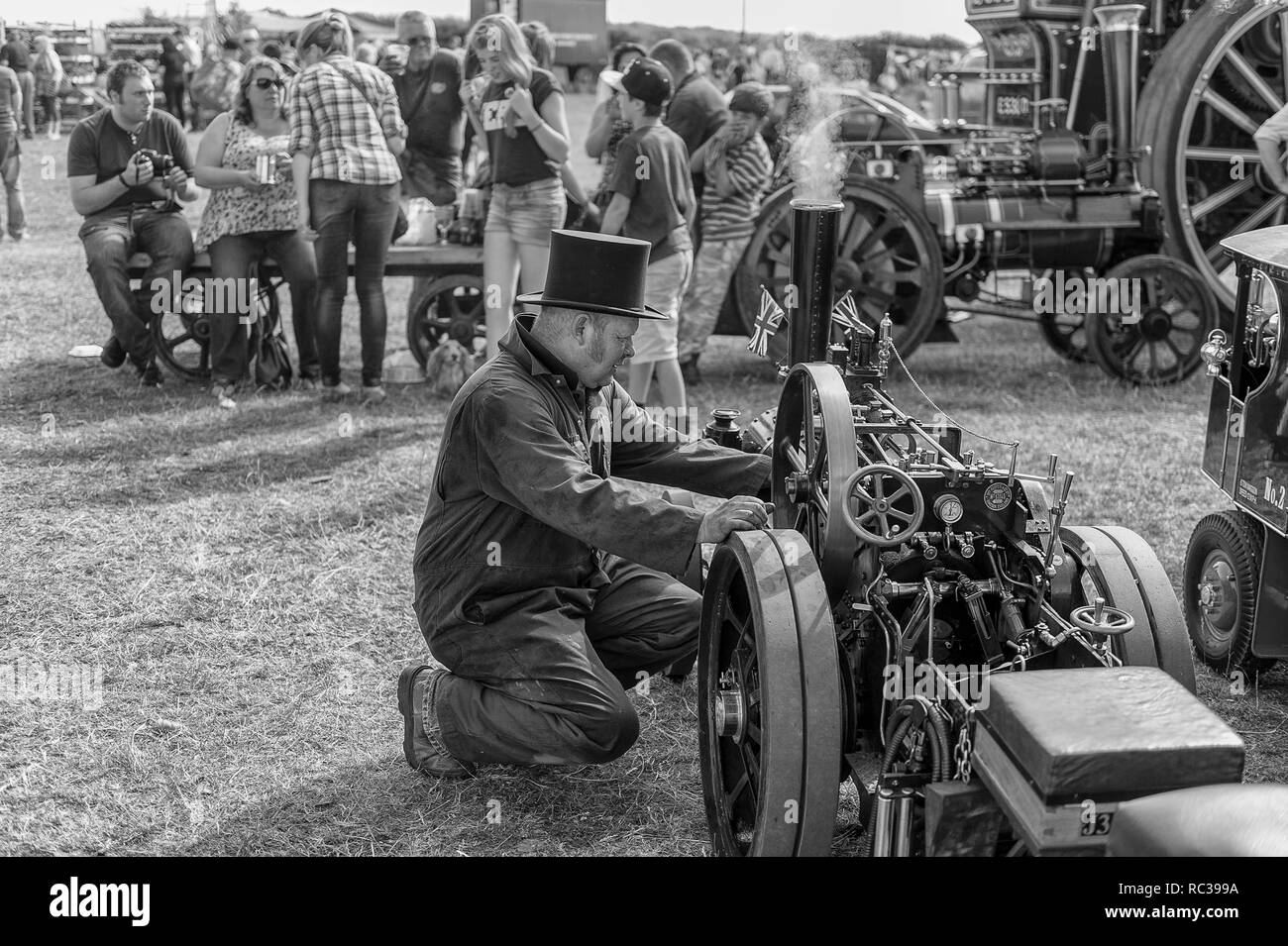 Homme à genoux en face de aminiature moteur de traction à la vapeur Preston Rally, Kent, Angleterre Banque D'Images