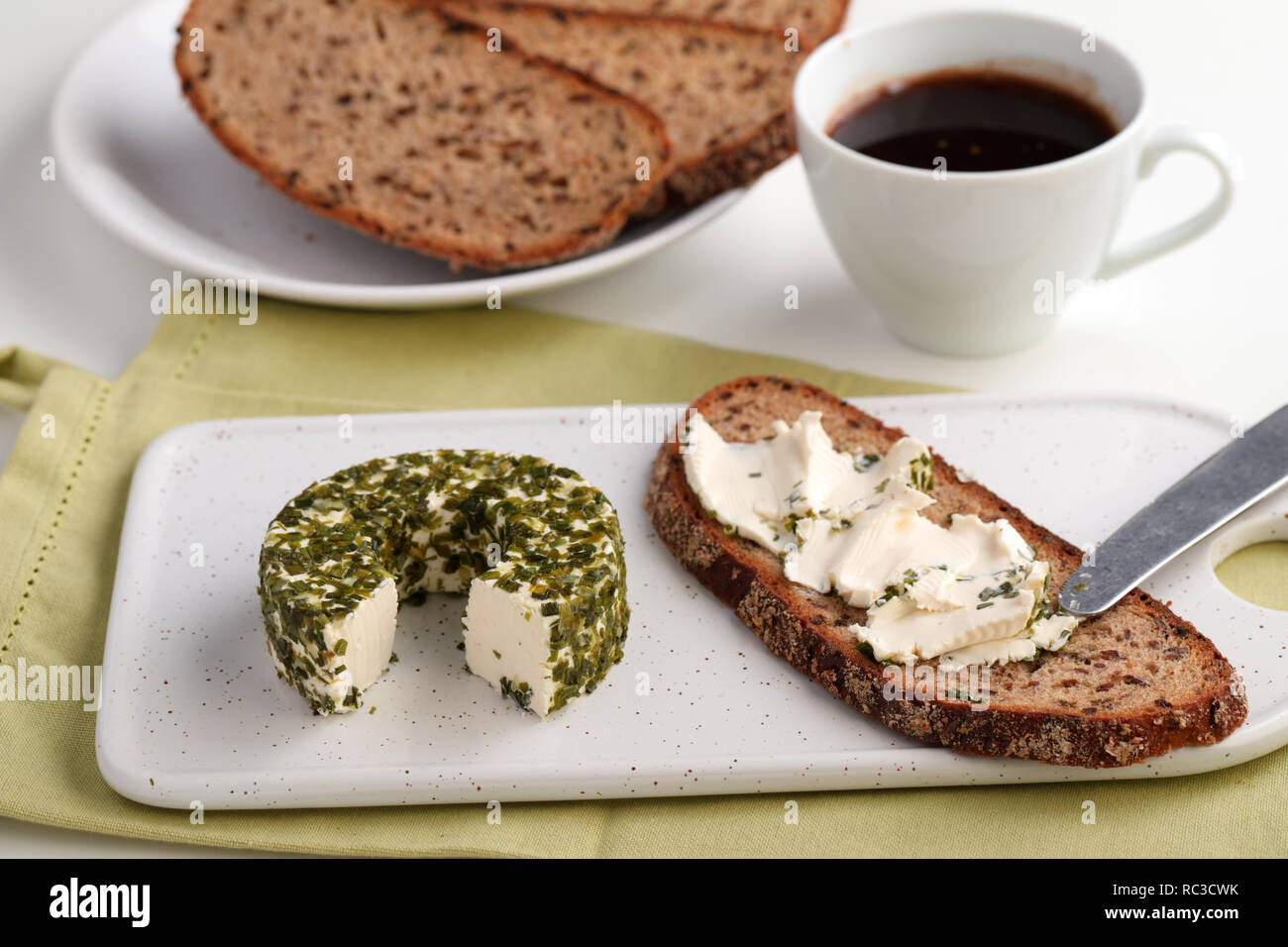 Faire de sandwich avec les fromages avec les verts sur une planche à découper en céramique pour le petit déjeuner avec café Banque D'Images