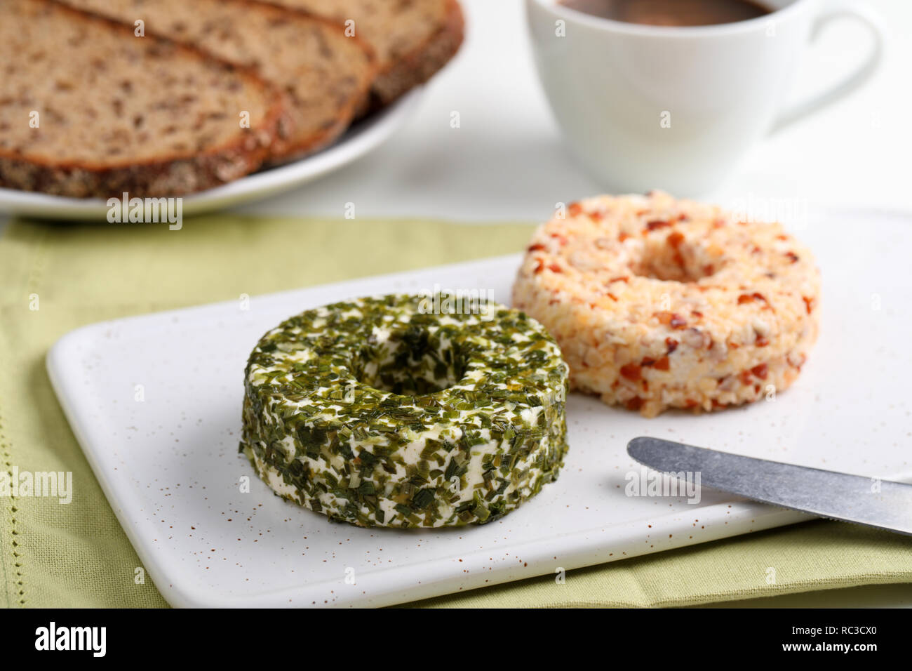 Séries de fromages letton avec verts, les noix et le poivre sur une planche à découper en céramique pour le petit déjeuner avec café Banque D'Images