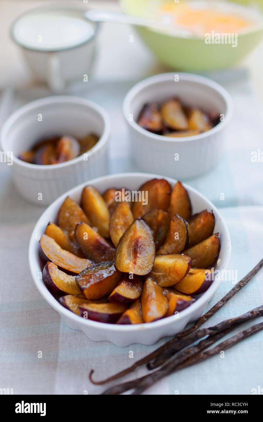 Ingrédients pour cuisiner clafoutis prune : prunes, farine, œufs, lait, vanille Banque D'Images