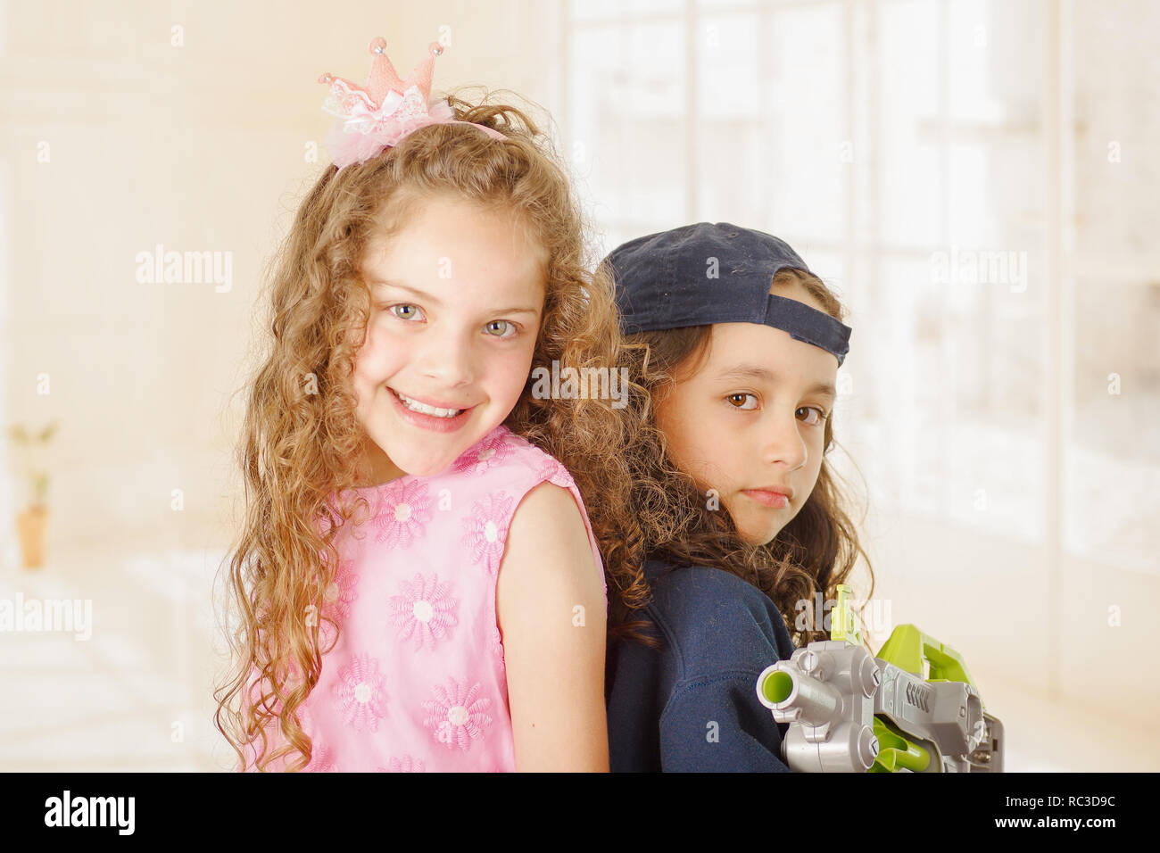 Close up de deux filles un garçon est wering vêtements et tenant un pistolet et de l'autre fille porte une robe princesse rose Banque D'Images