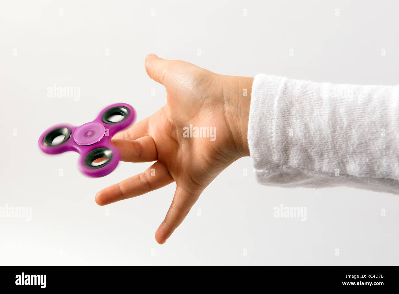 Spinner violet toy tournant sur les enfants du doigt. Côté vue en gros plan sur fond blanc Banque D'Images