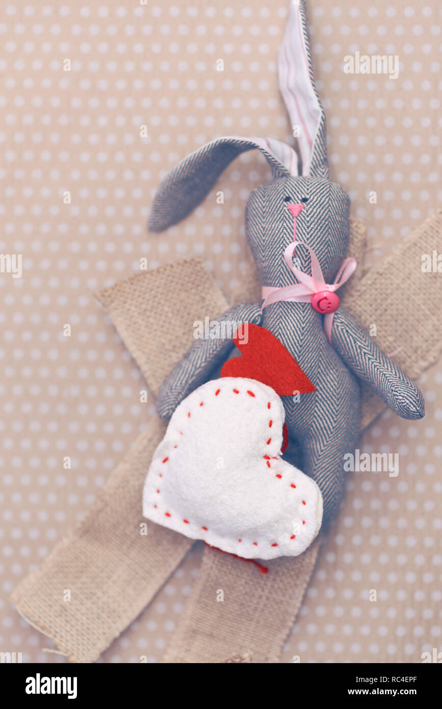 Valentines Day. Lapin tilde couché dans un tas de confectionner des coeurs. Valentine Day. Pendentif Coeur. L'espace pour le texte. Coeurs rouges. Dans les tons de l'image couleur à la mode Banque D'Images