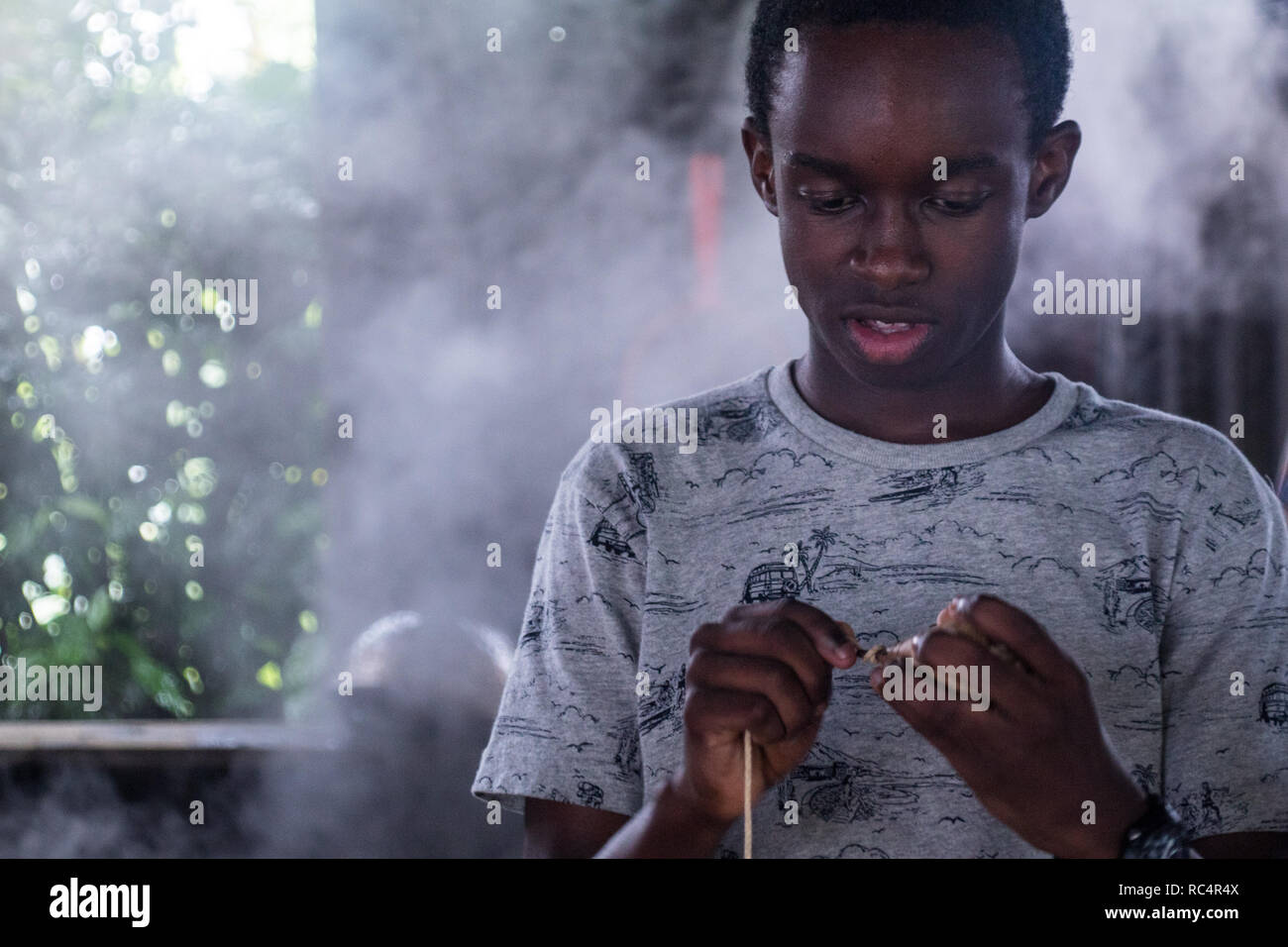Le portrait d'un garçon africain faisant quelques mains Banque D'Images