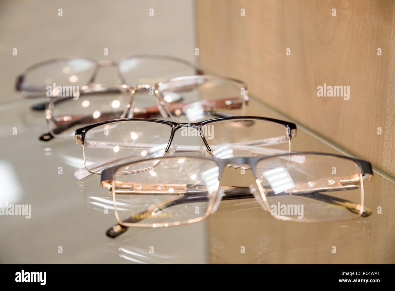 Un exposant de verres composé d'étagères de verres à la mode illustré sur  un mur au magasin d'optique. l'optique, les soins de santé et de concept  vision à lunettes opticien Photo Stock -