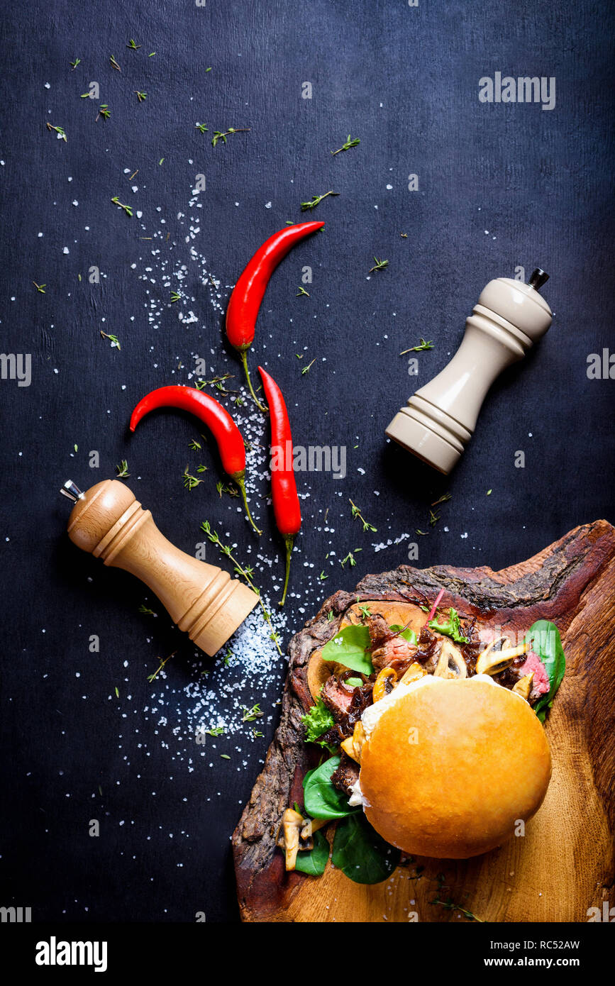 Burger Chef avec des morceaux de viande de bœuf, champignons et microgreens. Vue de dessus, copiez l'espace. Banque D'Images