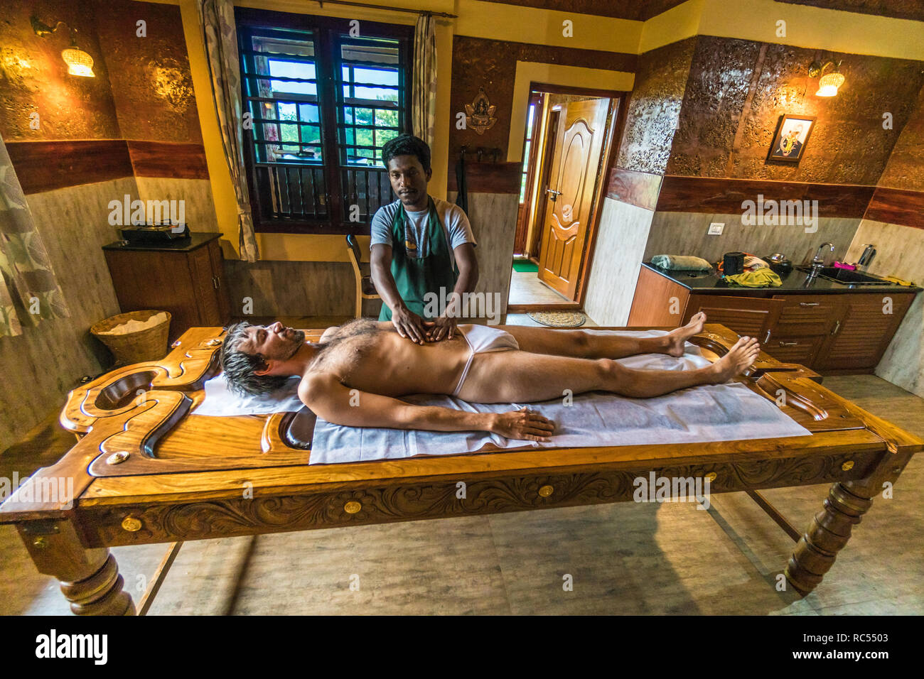Karnataka, Inde - le 20 août 2018 : Jeune homme d'entreprendre un massage du corps dans la région de spa. Rédaction d'illustration. Banque D'Images