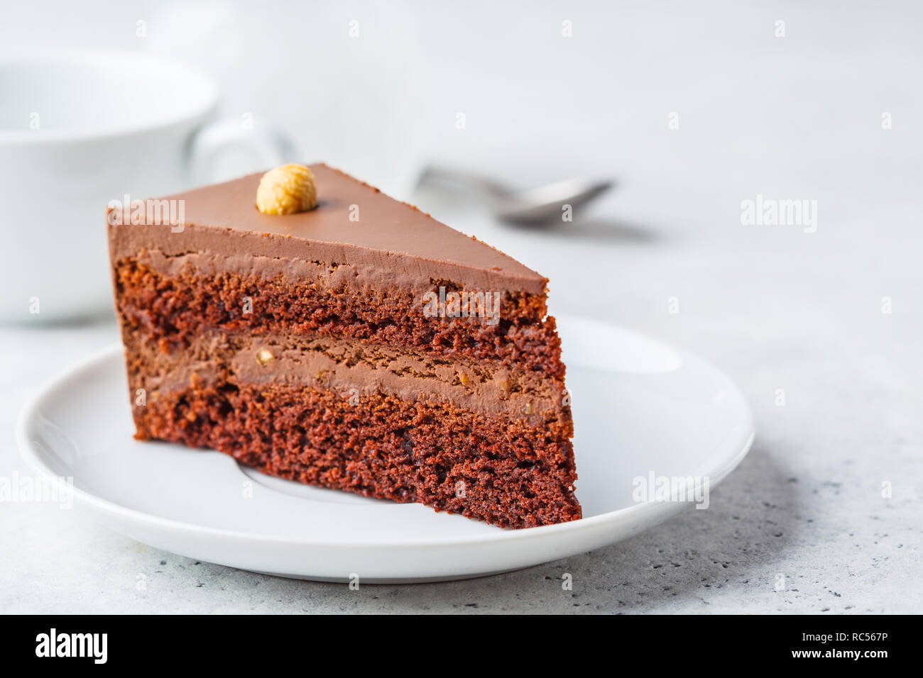 Morceau de gâteau au chocolat sur une assiette blanche, fond blanc, copie de l'espace. Dessert Vegan à base de plante, la société food concept. Banque D'Images