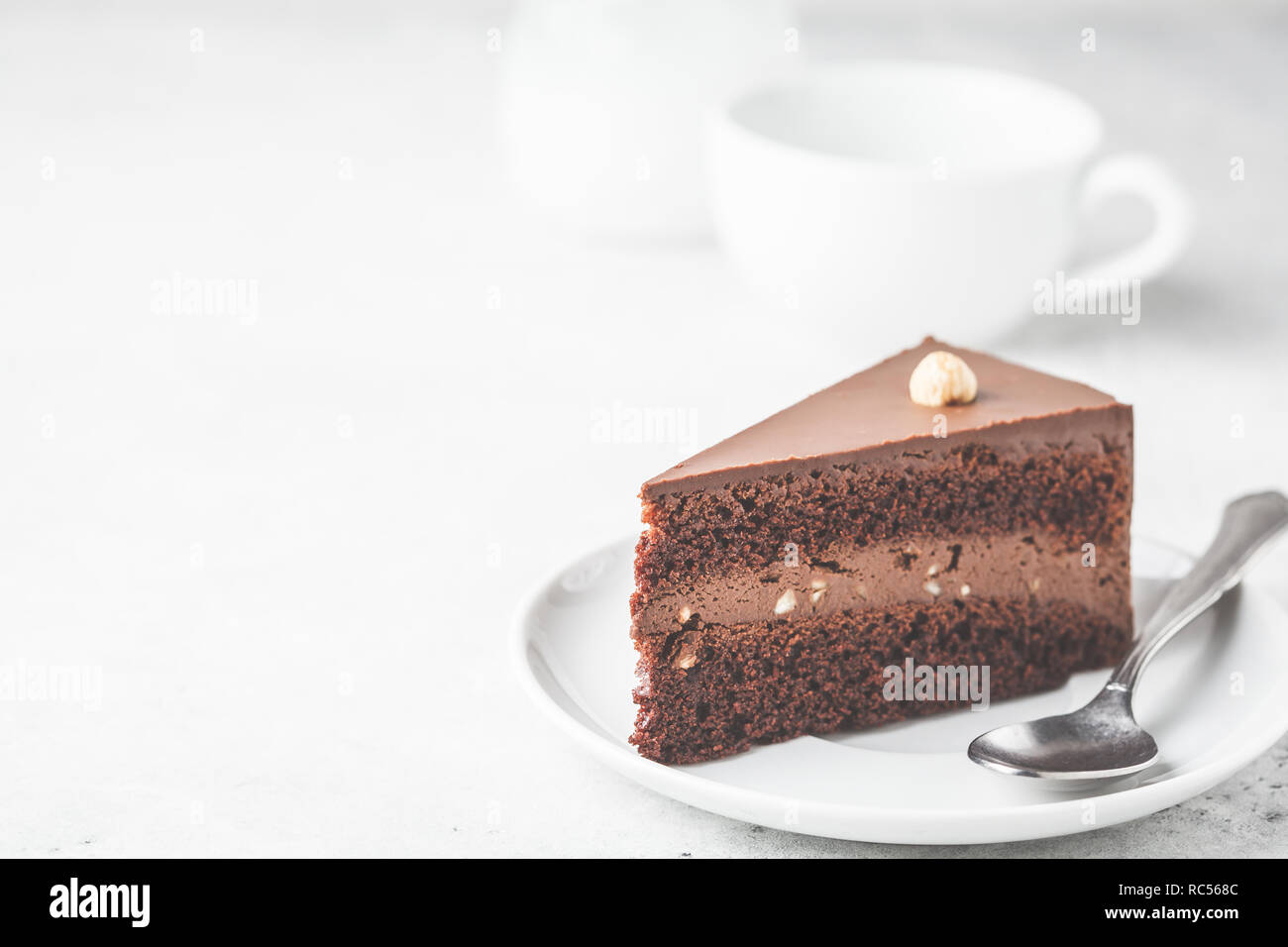 Morceau de gâteau au chocolat sur une assiette blanche, fond blanc, copie de l'espace. Dessert Vegan à base de plante, la société food concept. Banque D'Images