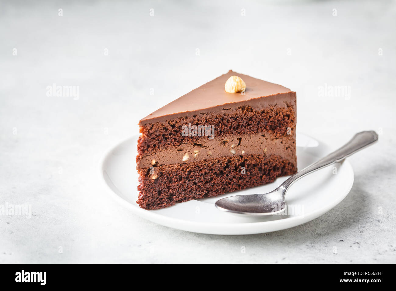 Morceau de gâteau au chocolat sur une assiette blanche, fond blanc, copie de l'espace. Dessert Vegan à base de plante, la société food concept. Banque D'Images