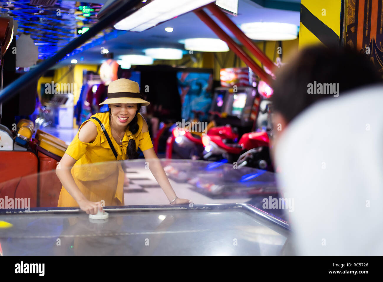 Femme de jouer aux jeux d'arcade au centre de divertissement Banque D'Images