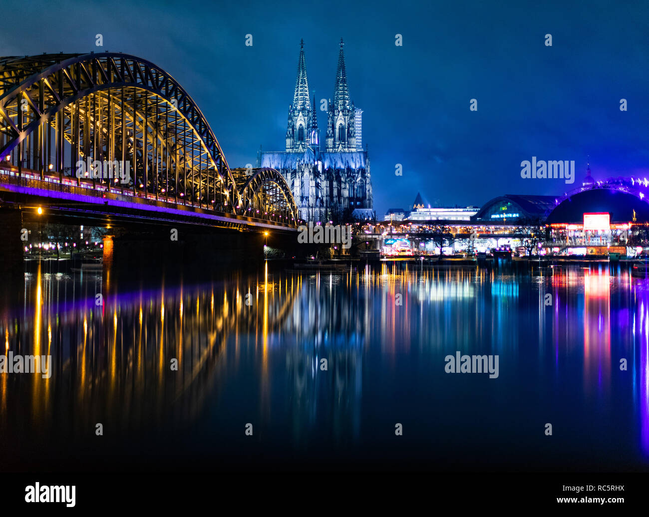 Hohenzollernbrücke mourir (l), der Köllner Dom (m) und der Musical Dome (r) spiegeln sich bei blauer Stunde dans Regenwasser auf einer Mauer. Banque D'Images
