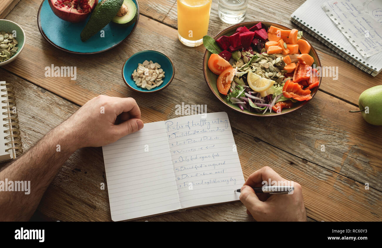 L'homme fait une liste d'aliments sains. Concept de nourriture de régime de vie sain Banque D'Images