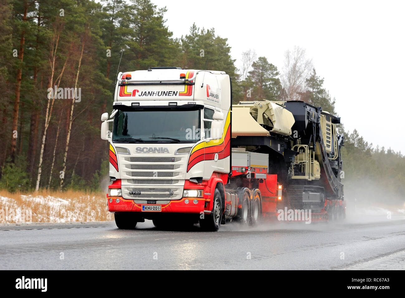 Raasepori, Finlande - le 27 décembre 2018 : Scania R730 camion de Janhunen Metso Lokotrack LT106 tire la mâchoire mobile de concassage sur remorque par temps humide. Banque D'Images