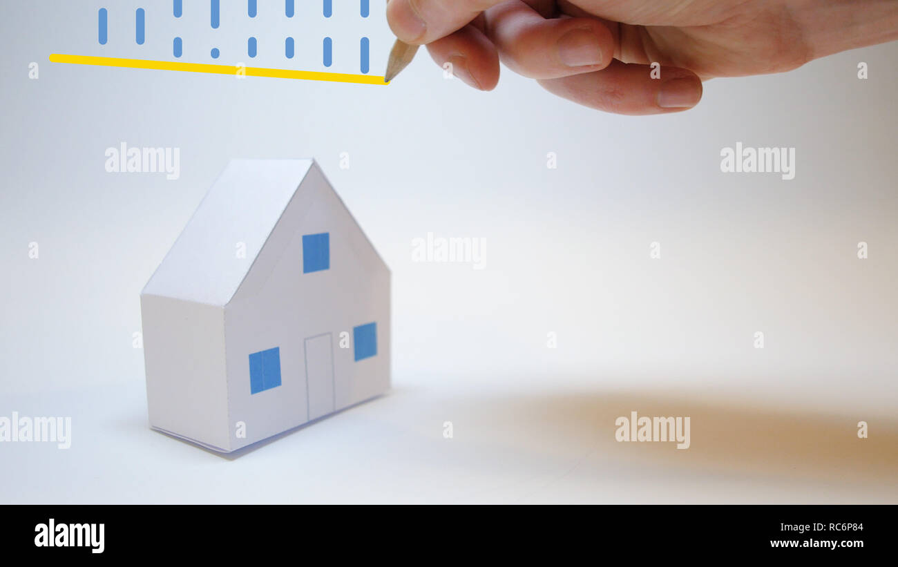 La main d'un assureur protège un paper house de catastrophes naturelles Banque D'Images