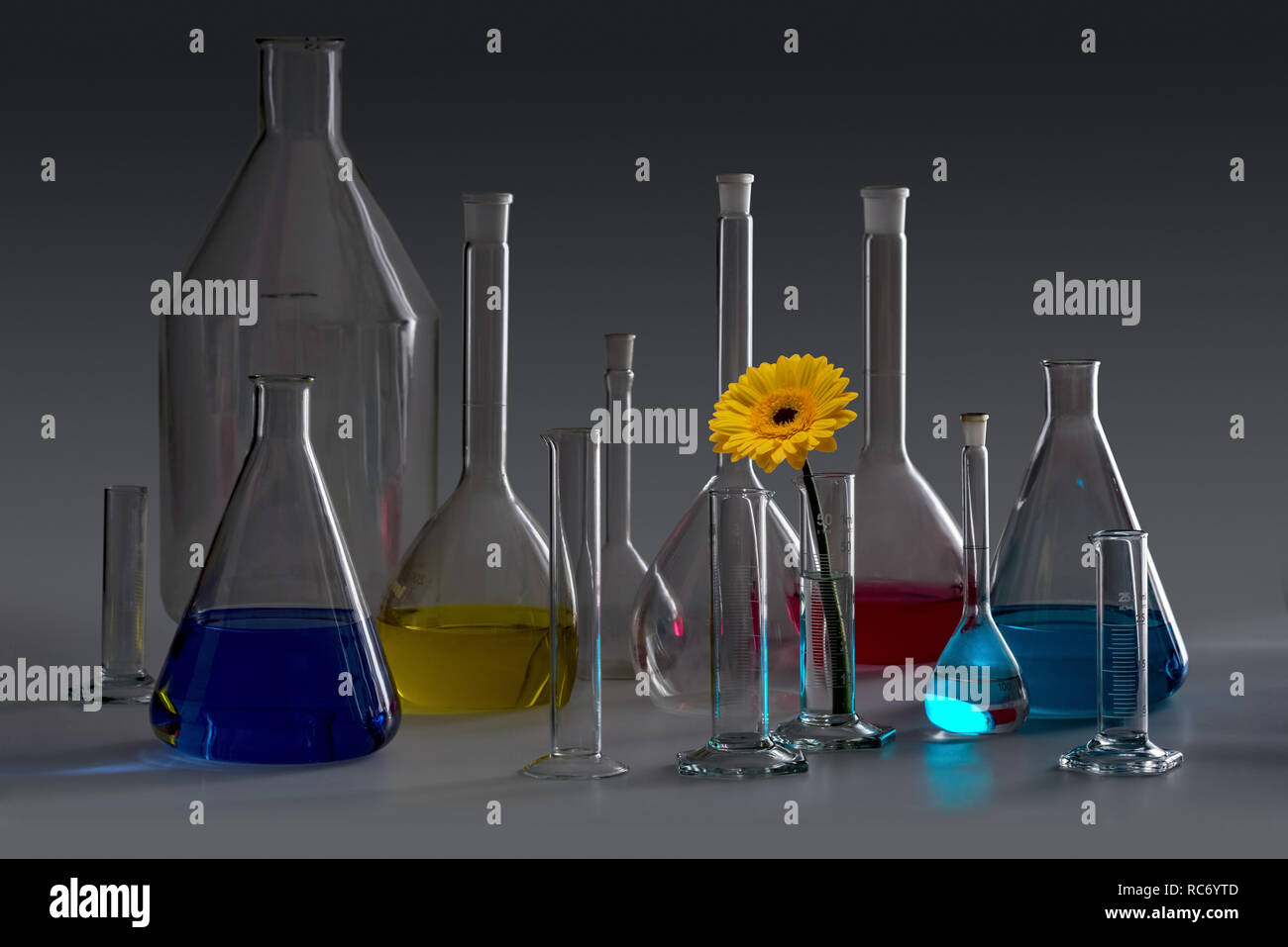 Variété de verrerie de laboratoire en partie rempli y compris le capitule en ambiance sombre Banque D'Images