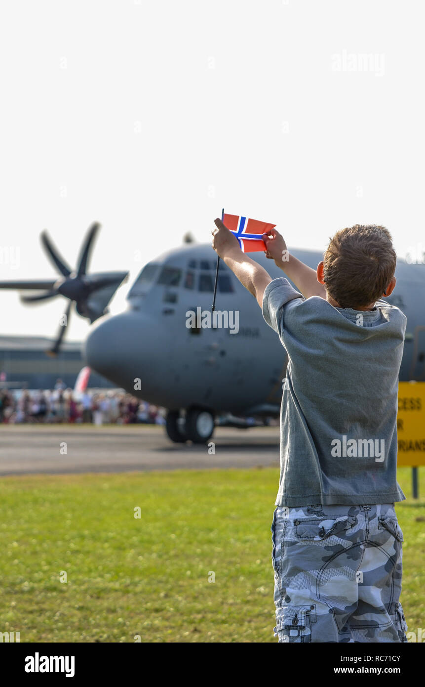 Royal Norwegian Air Force C-130J Hercules de Lockheed appelé Nanna d'être accueilli à North Weald, Essex, UK par boy holding pavillon norvégien Banque D'Images