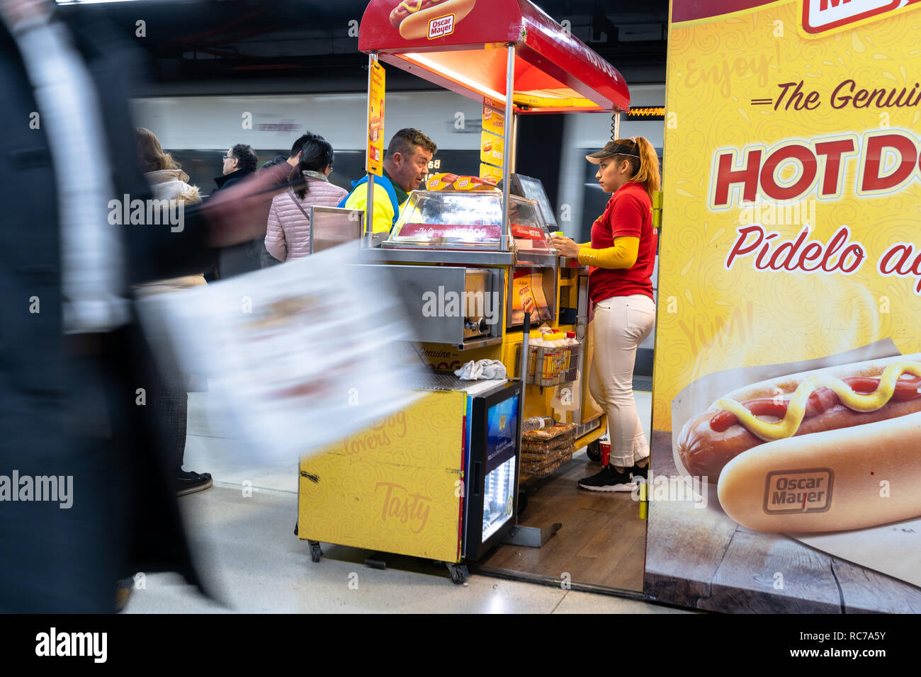 Au service de hot-dog un hot-dog à un voyageur dans un stand de hot-dog à la gare de Barcelone, ​​Spain Banque D'Images