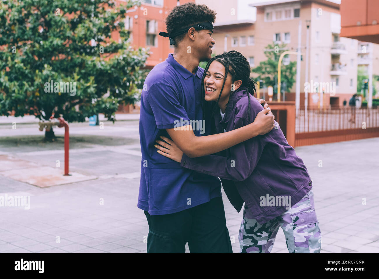 Frère et sœur hugging in town square, Milan, Italie Banque D'Images