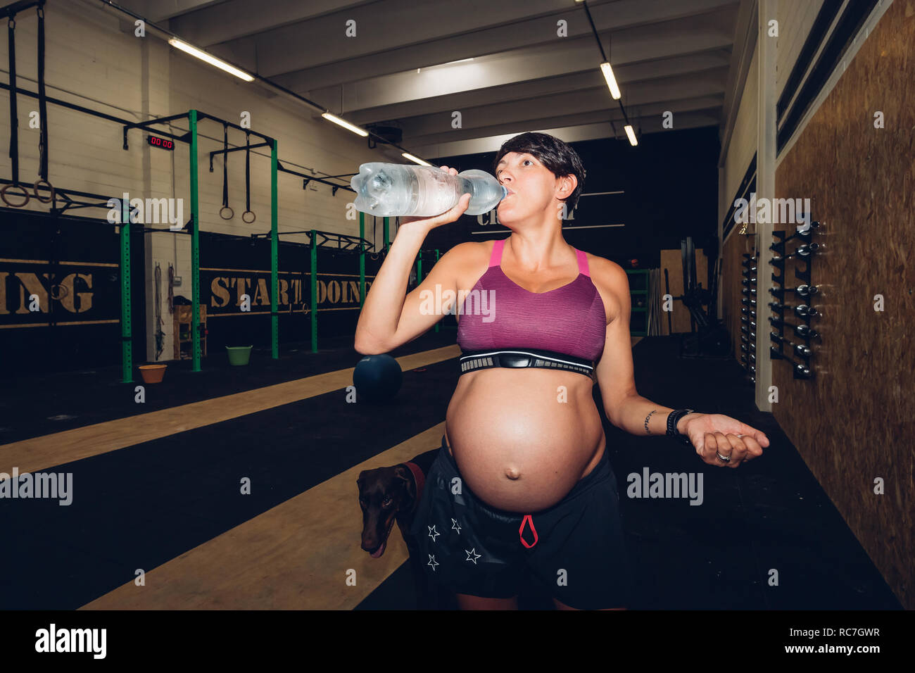 Femme enceinte de boire de l'eau en bouteille de sport Banque D'Images