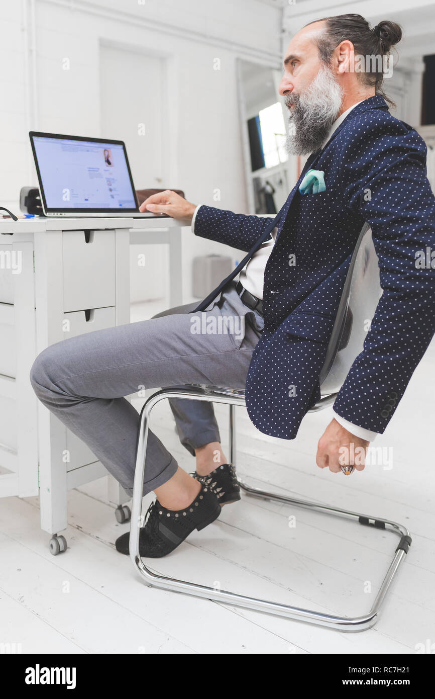 Classy businessman looking at laptop sur office 24 Banque D'Images