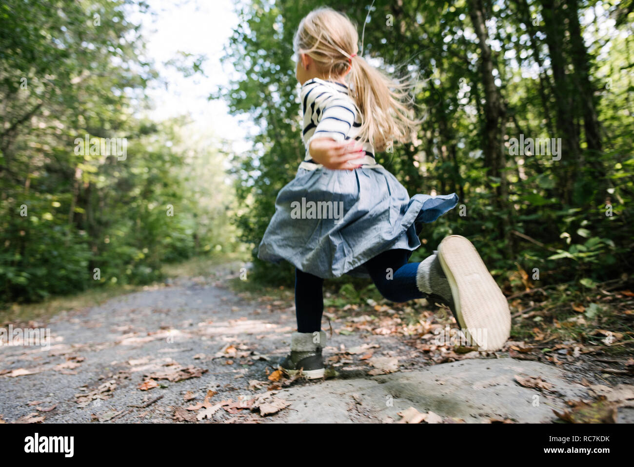Petite fille courir en forêt Banque D'Images