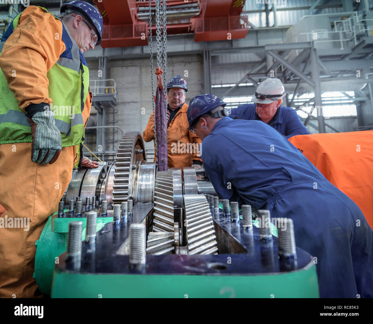 Grutage ingénieurs grand pignon en place dans le hall de la turbine de centrale nucléaire Banque D'Images