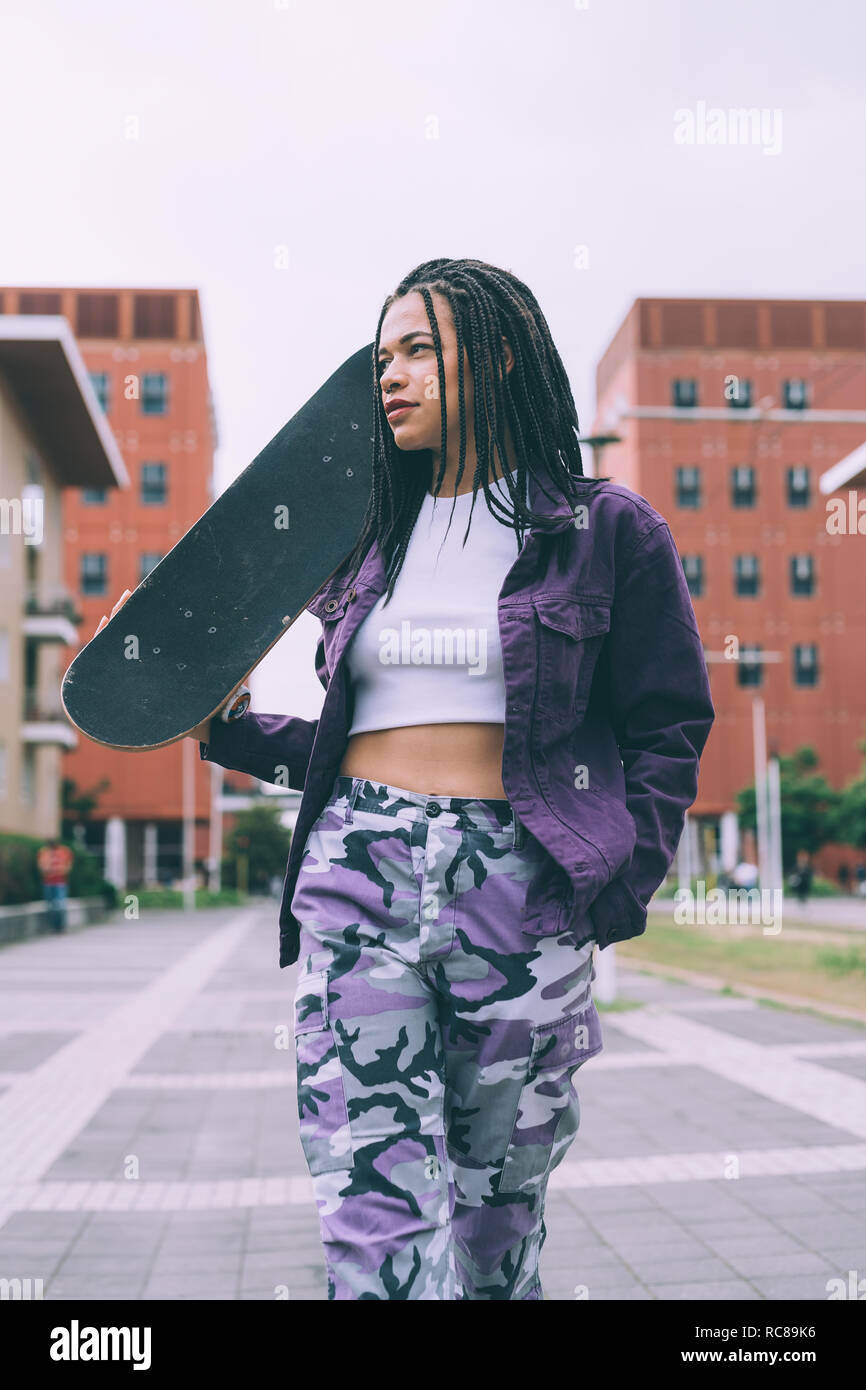Femme avec skateboard, Milan, Italie Banque D'Images