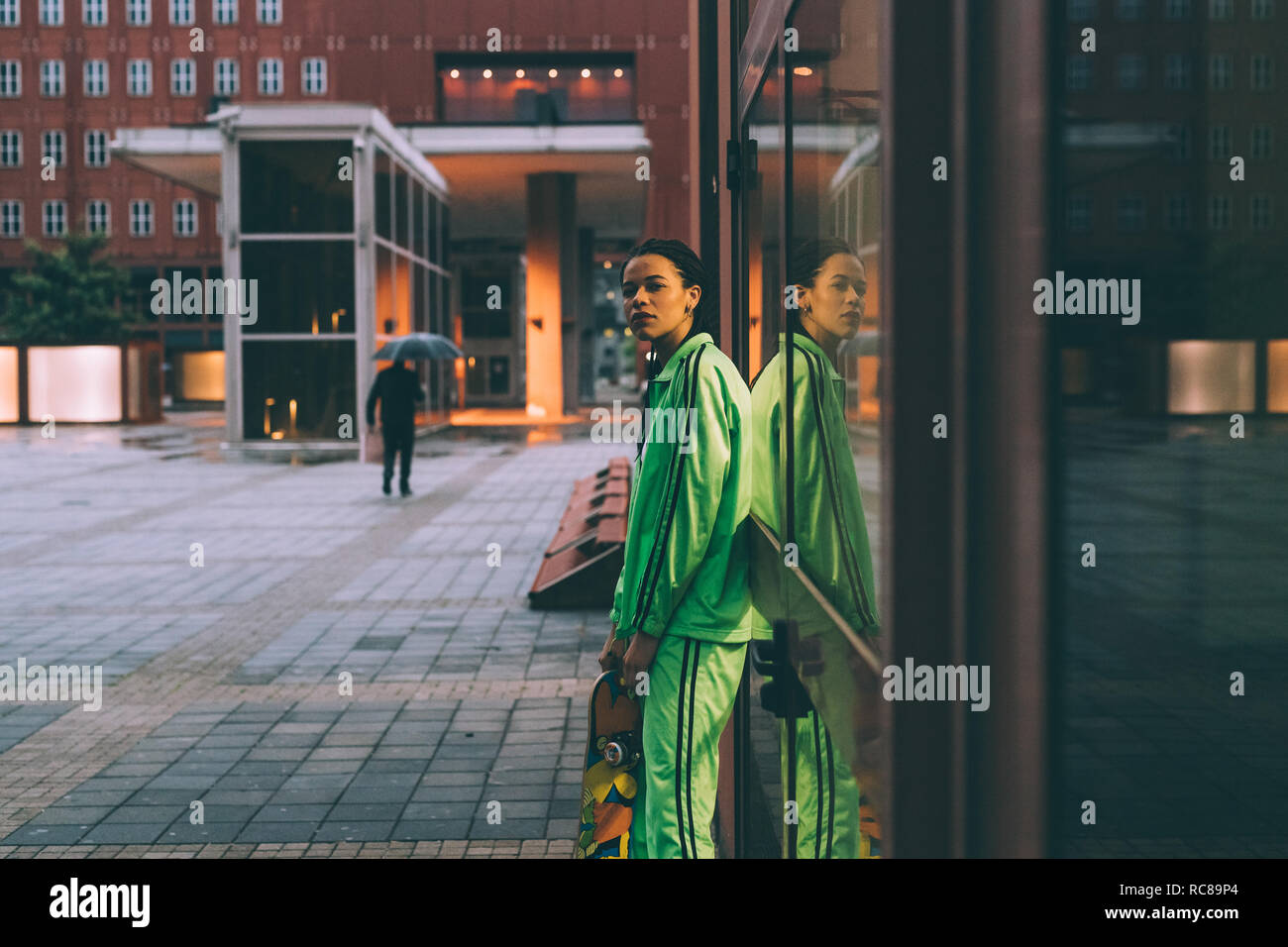 Woman leaning against glass window, Milan, Italie Banque D'Images