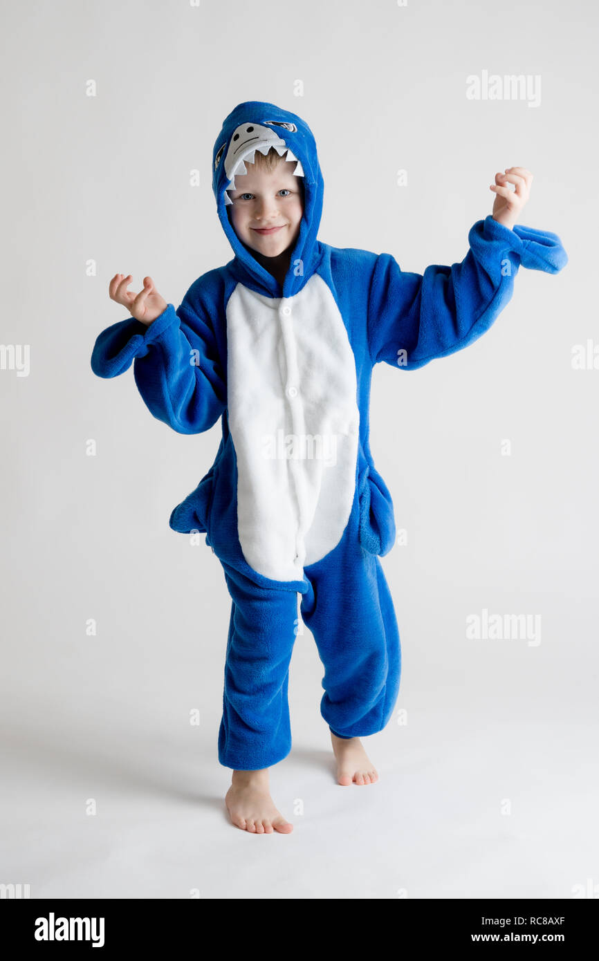 Joyeux petit garçon posant sur un fond blanc en pyjama kigurumi costume de requin  bleu Photo Stock - Alamy