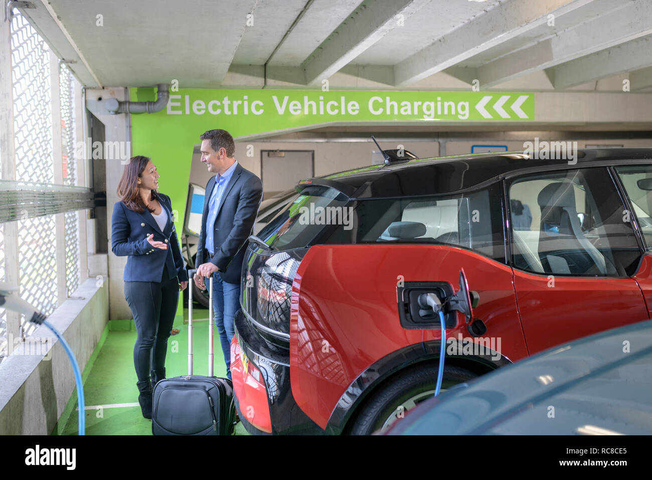 L'homme et la femme voiture électrique de charge à charge bay, Manchester, UK Banque D'Images