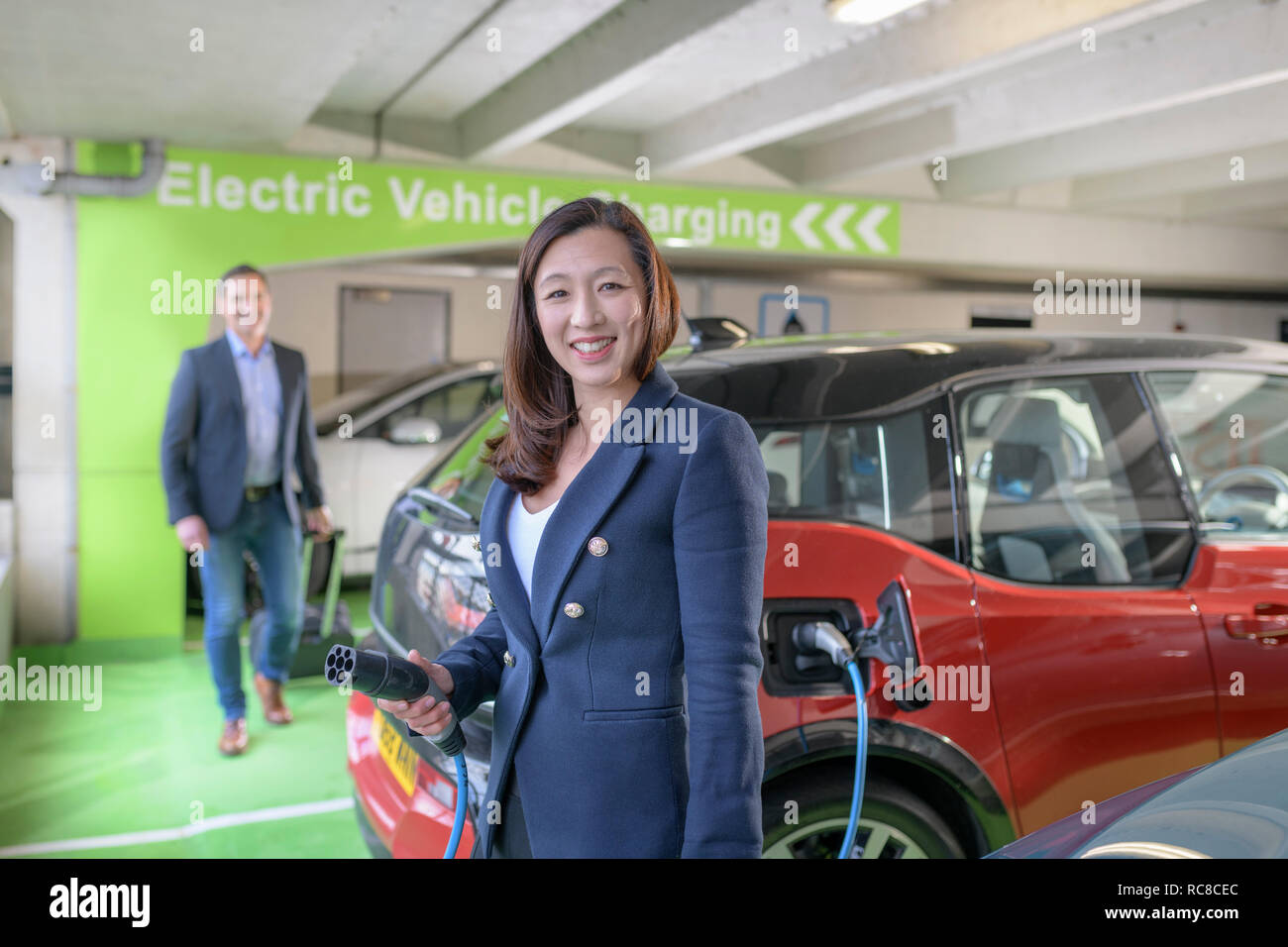 L'homme et la femme voiture électrique de charge à charge bay, Manchester, UK Banque D'Images