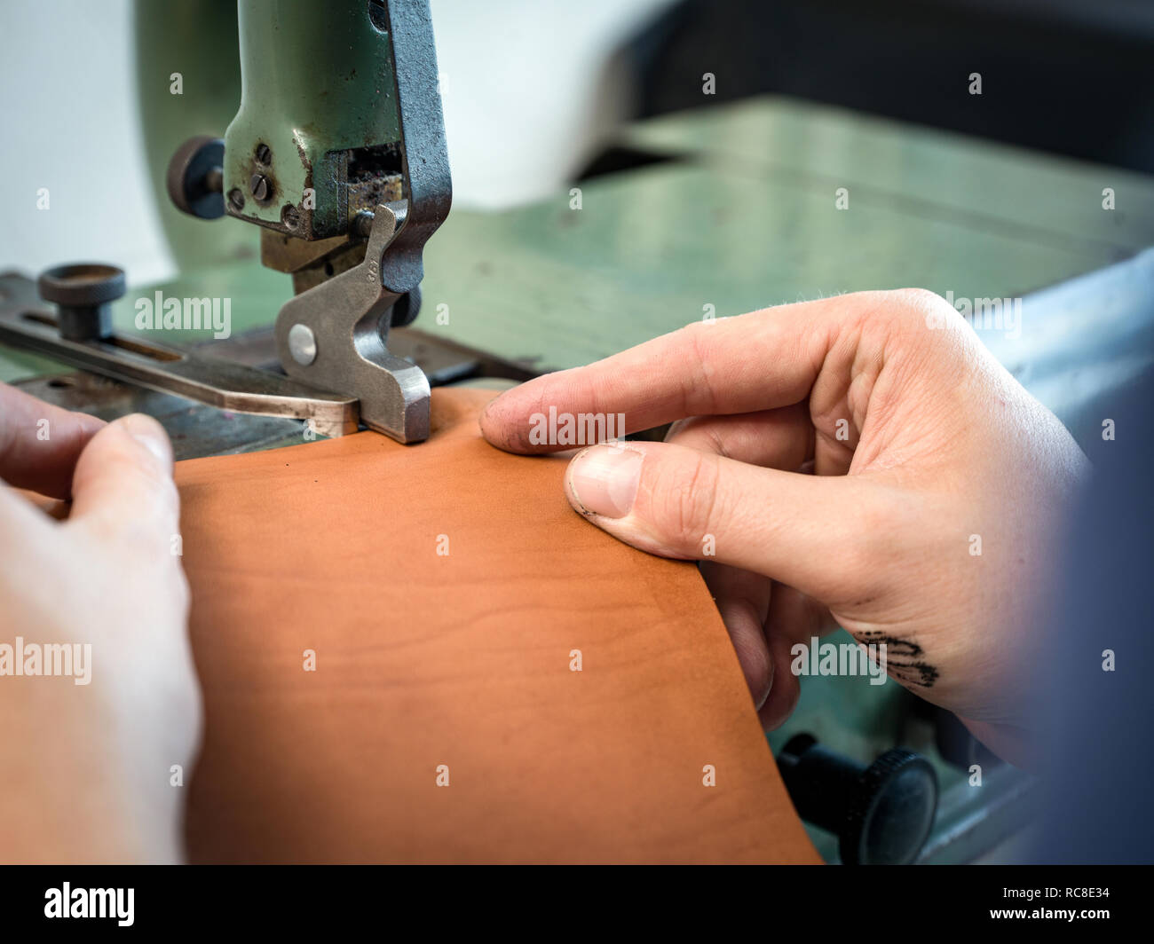 Leatherworker usinage à l'aide de sac à main en cuir edge en atelier, Close up of hands Banque D'Images