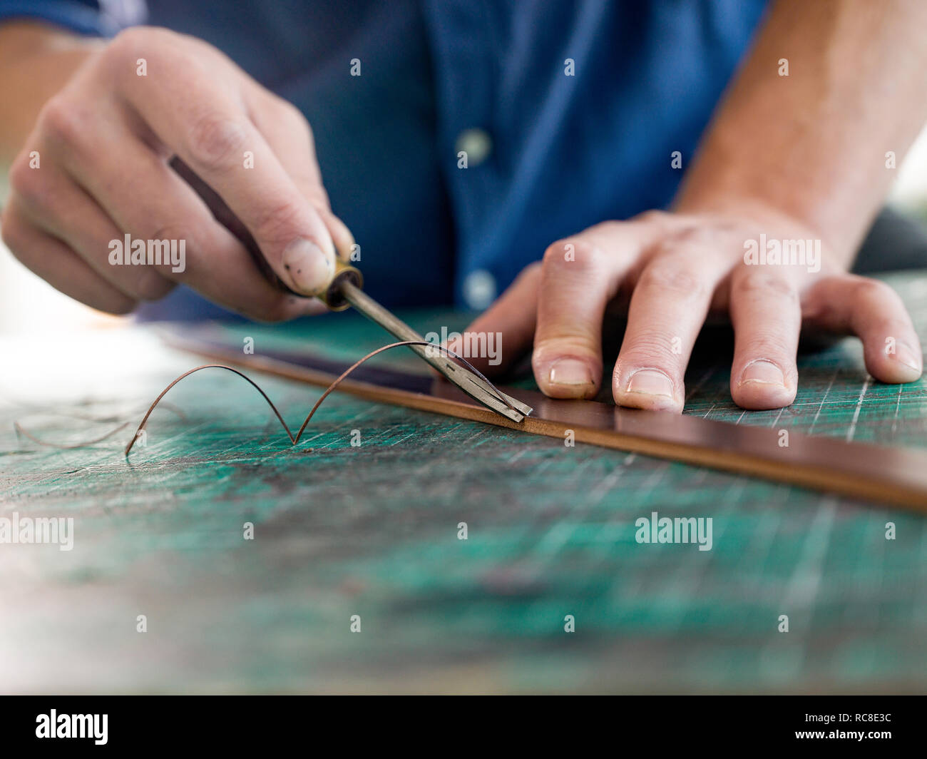 Leatherworker en cuir de fraisage pour sac bracelet en atelier, Close up of hands Banque D'Images