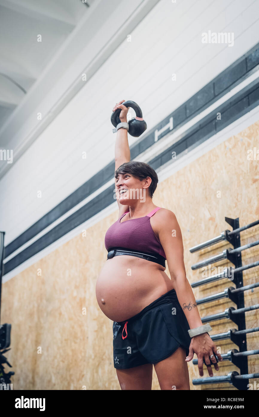 Femme enceinte à l'aide de sport à kettlebell Banque D'Images