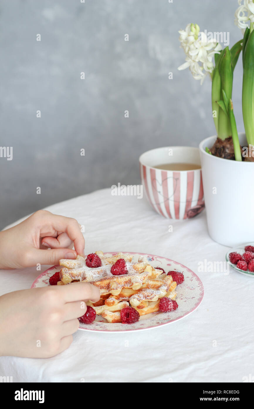Table du petit déjeuner avec des gaufres fraîches et des framboises et d'un plateau sur la table Banque D'Images