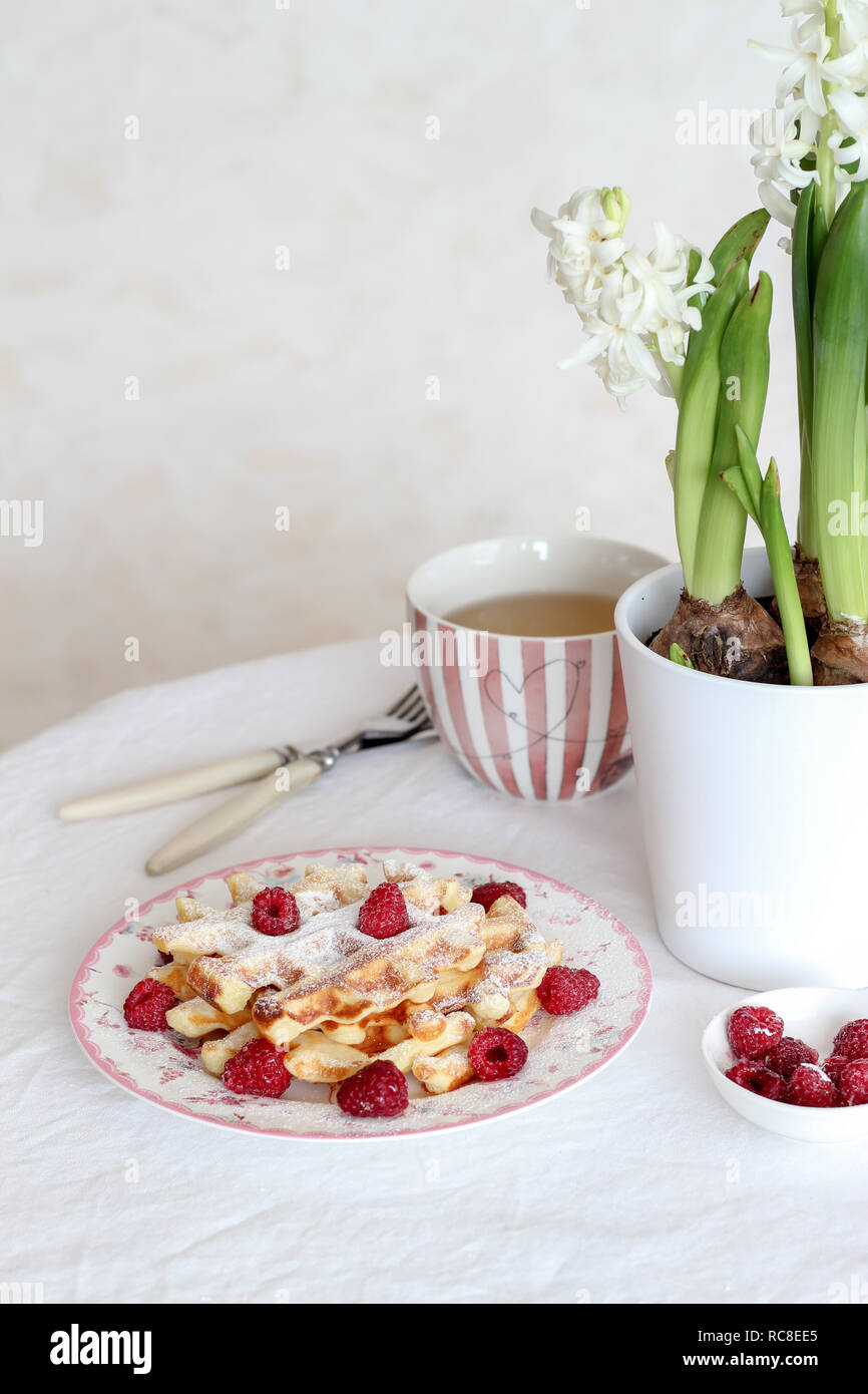Table du petit déjeuner avec des gaufres fraîches et des framboises sur la table Banque D'Images