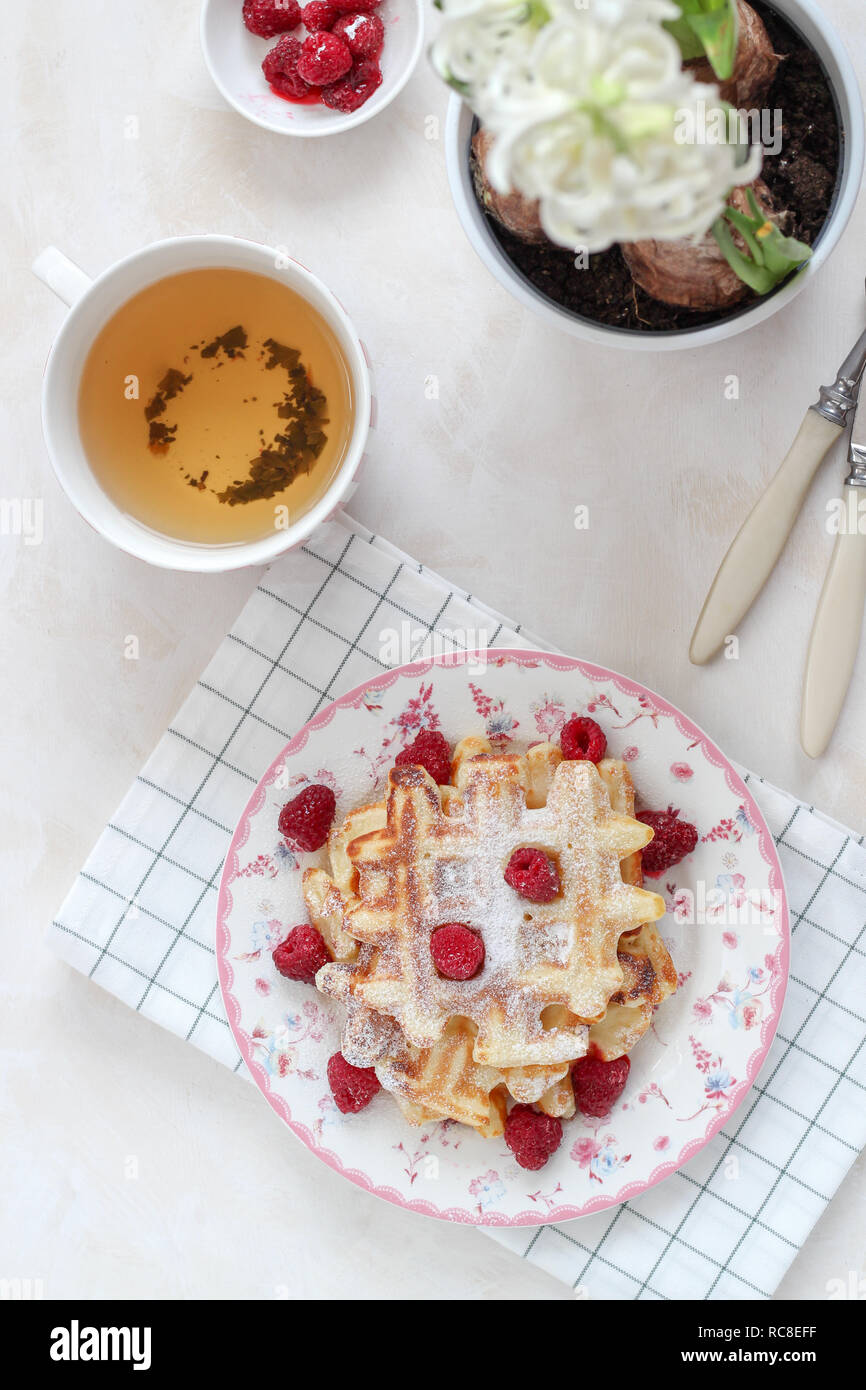 Petit-déjeuner avec télévision jeter des gaufres fraîches et des framboises sur la table Banque D'Images