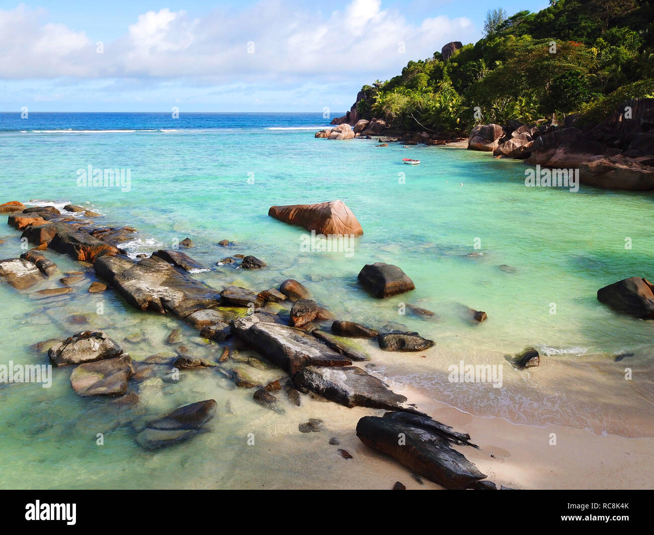 Plage sur Mahe Seychelles ;. Un bateau de pêche dans le contexte et les paumes pendant vers le bas à la plage. Une destination de vacances parfaite. Banque D'Images