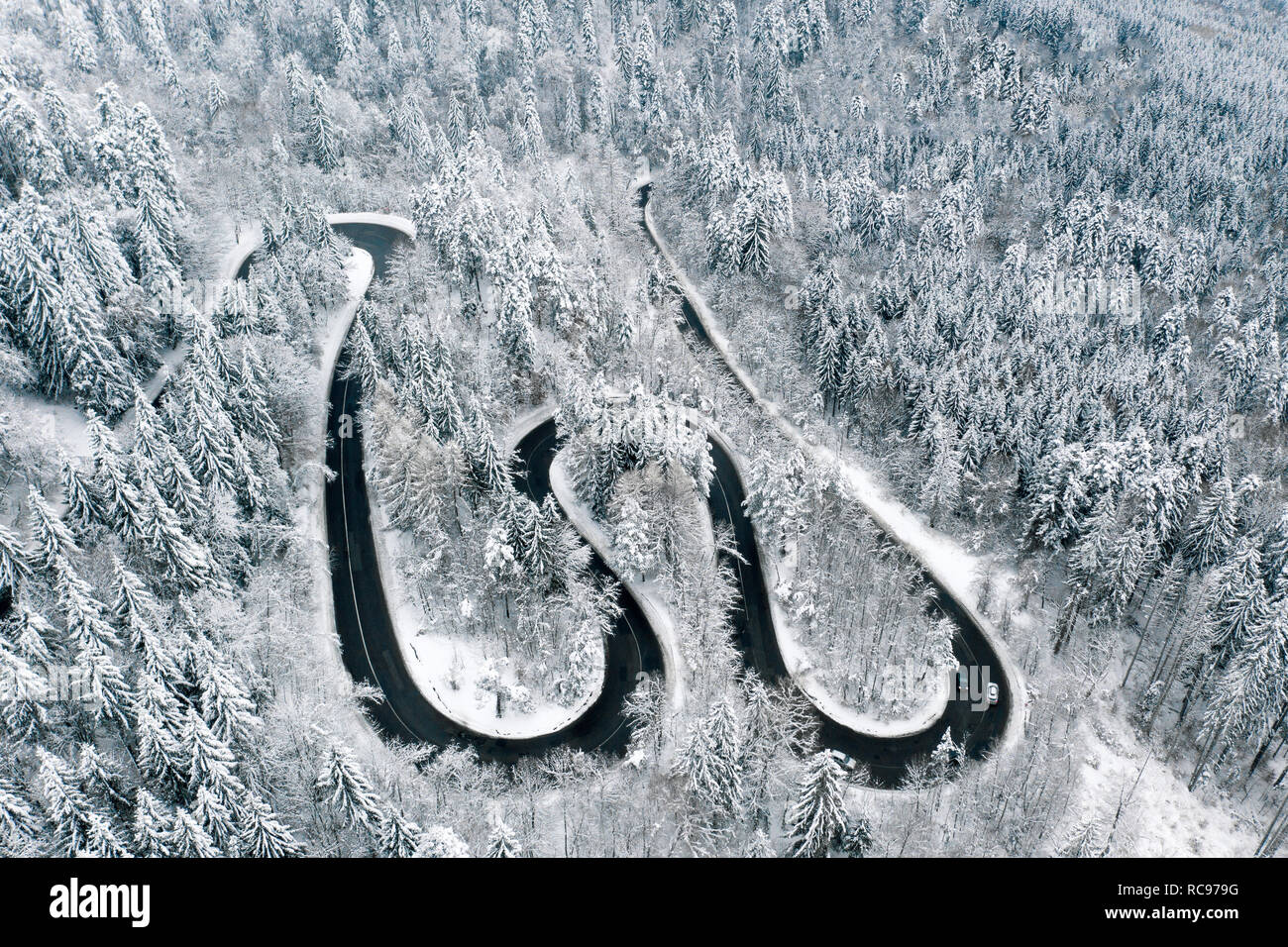 Temps de neige dans les montagnes avec des courbes sinueuses road à travers la forêt Banque D'Images